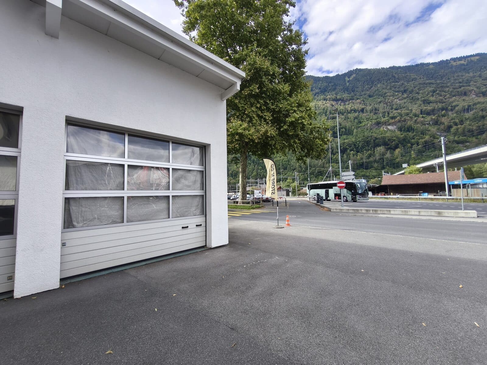 View from Store N' Go towards Interlaken Ost station — the yellow flag marks the entrance